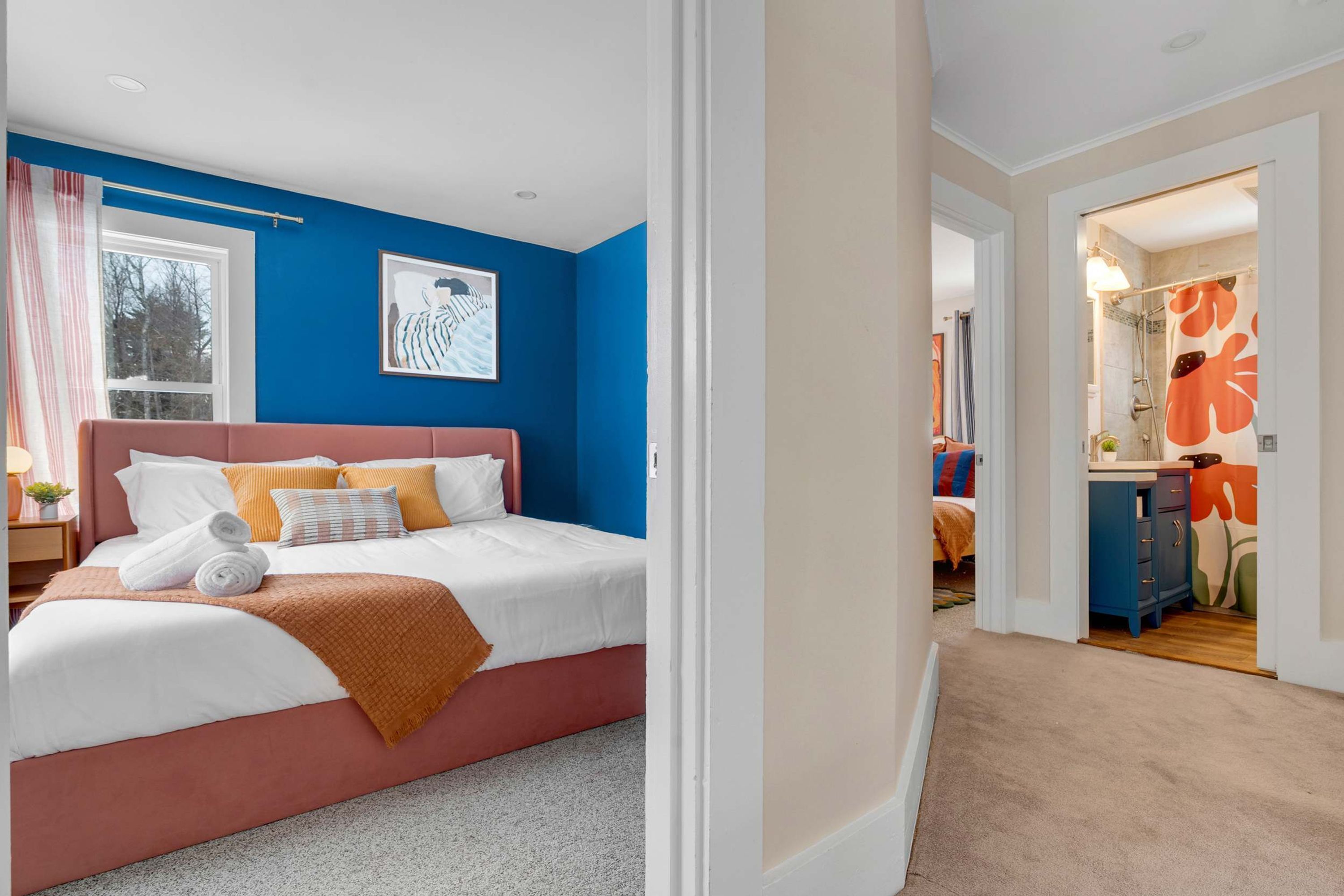 A bedroom with a bed, pillows, a bedside table, and a window.