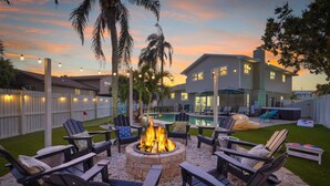 A backyard with a fire pit, outdoor seating, a pool, and a large house. - 4 Minutes to Beach Pool Hot Tub Game Room (Seminole)