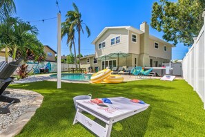 A backyard with a swimming pool, outdoor furniture, and a dining table. - 4 Minutes to Beach Pool Hot Tub Game Room (Seminole)