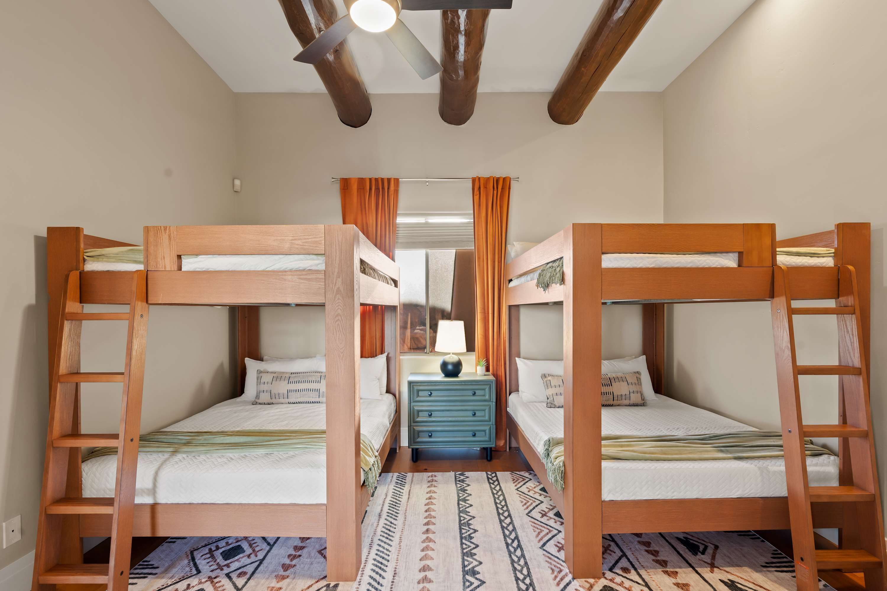 A room with bunk beds, a dresser, and a mirror.