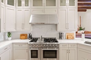 A modern kitchen with white cabinetry, a stainless steel range, and an oven. - The Good Life Oasis Luxury 5BR Home Sleeps 16 (Glendale)