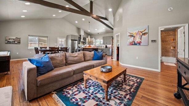 A spacious living room with a brown leather sofa, a wooden coffee table, and a patterned rug. - The Live Oak Pickleball-hot Tub-dog Friendly (Fredericksburg)