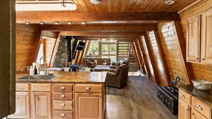 L’intérieur d’une cabane comprenant une cuisine, un coin repas et un salon.