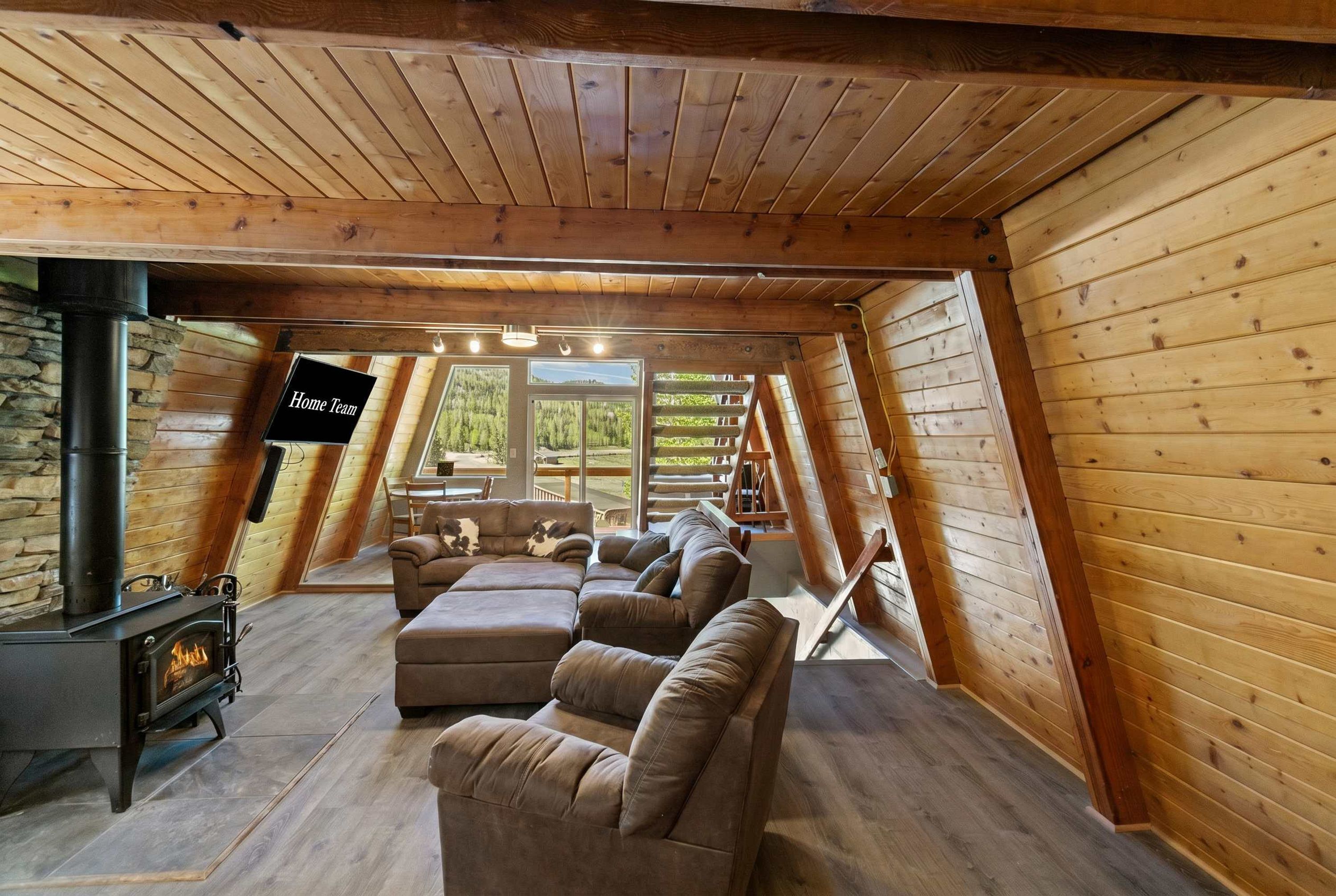 A cozy attic room with a fireplace, a sofa, and a TV.