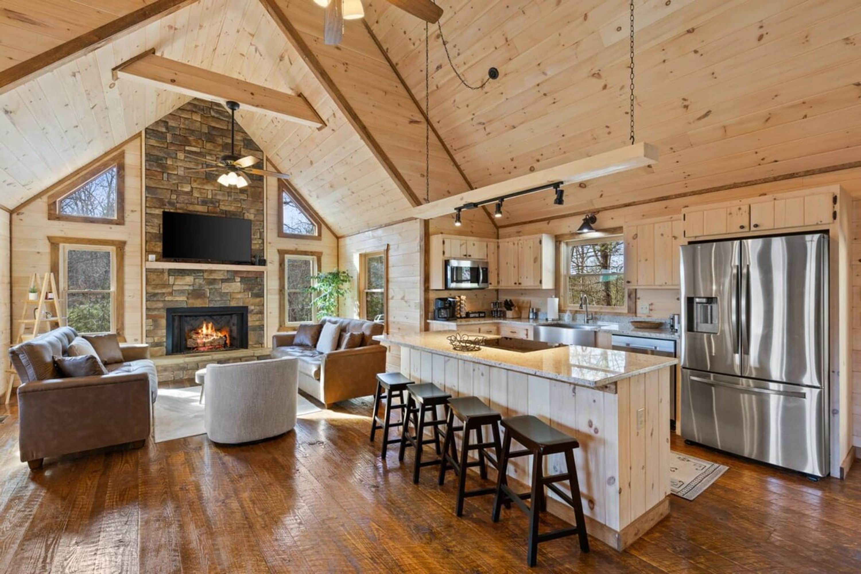 A spacious kitchen with a large island, stainless steel appliances, and a stone fireplace.