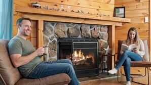 A cozy room with a stone fireplace, wooden walls, and a comfortable seating area. - Cozy Mountain Escape Hot Tub Fire Pit Views (Blue Ridge)