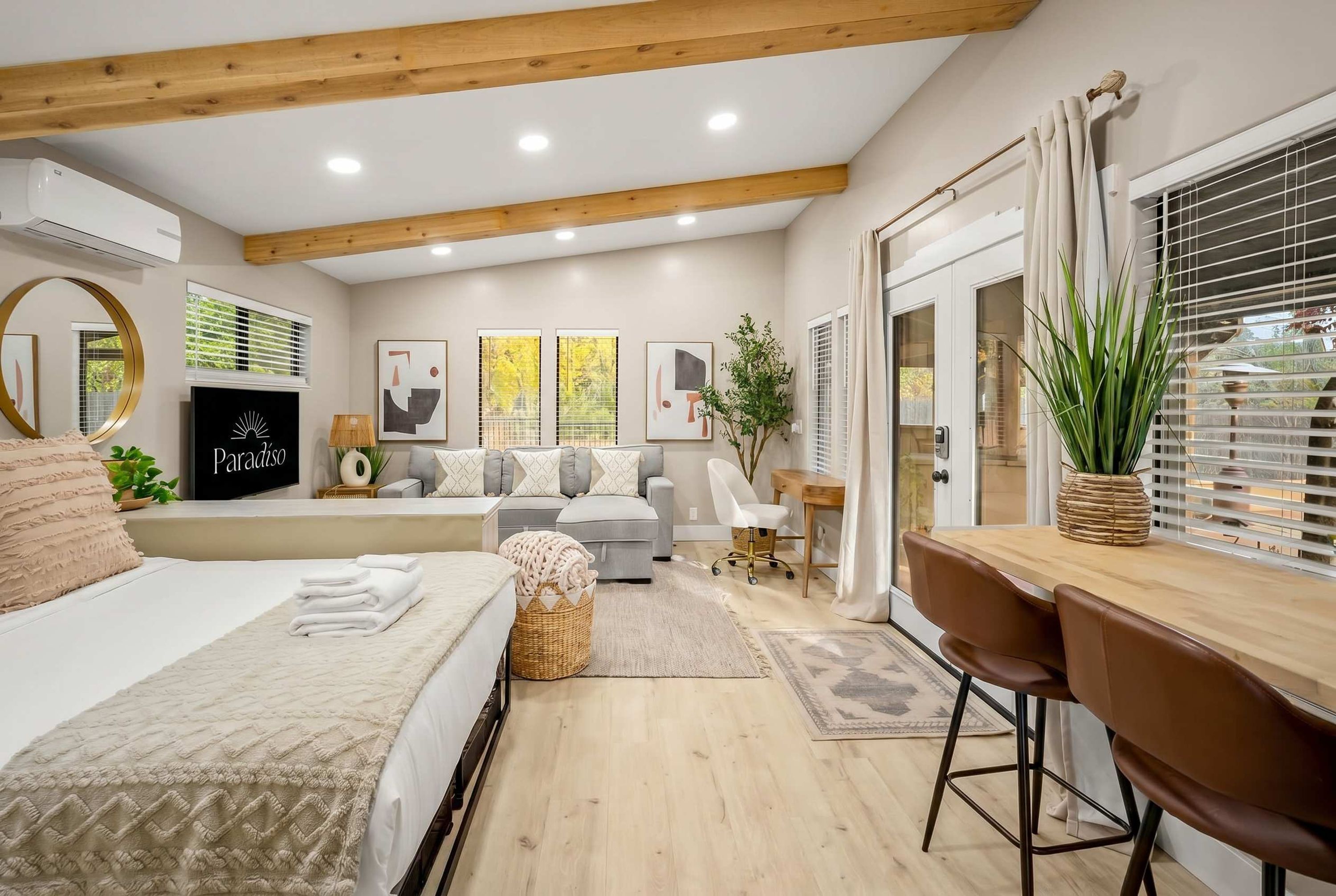 A modern bedroom with a bed, a desk, and a seating area.