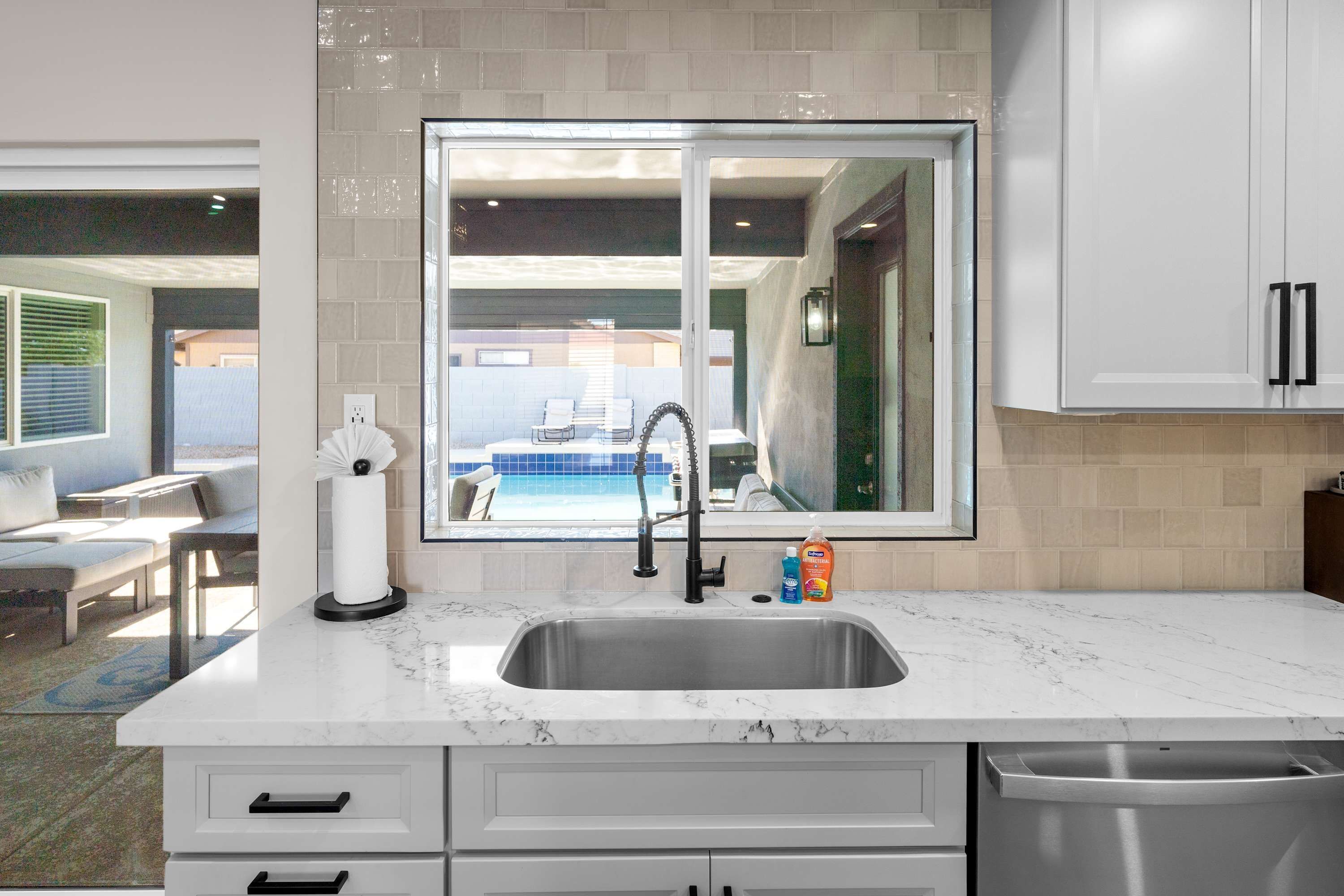 A modern kitchen with a large window, a sink, and a countertop.