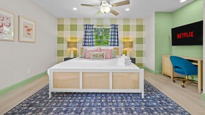 A bedroom with a bed, a ceiling fan, a wall-mounted TV, and a desk with a chair. - Resort Style Backyard Tiki Bar Renovated Pool (Largo)