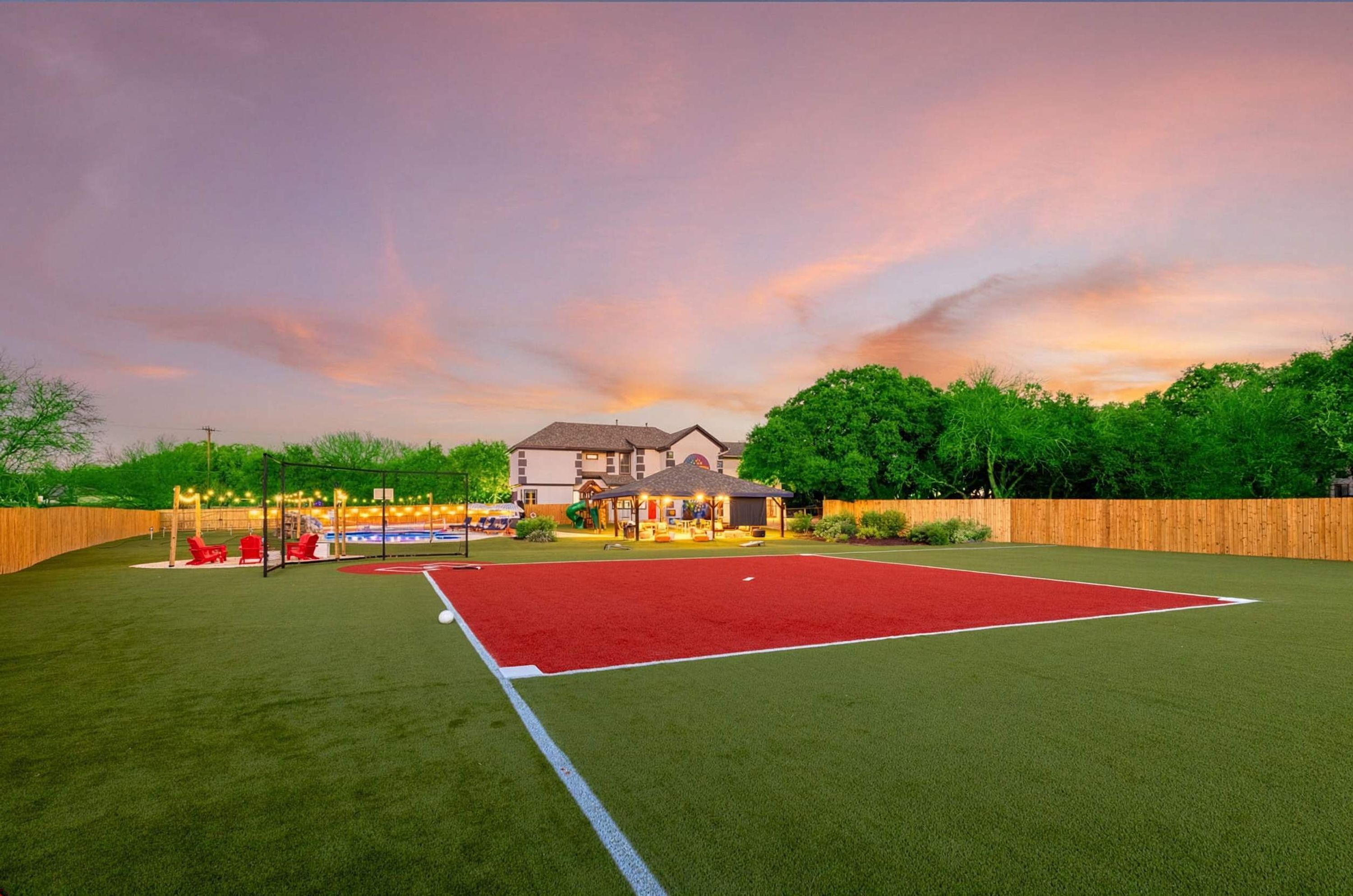 A sports field with a house in the background.