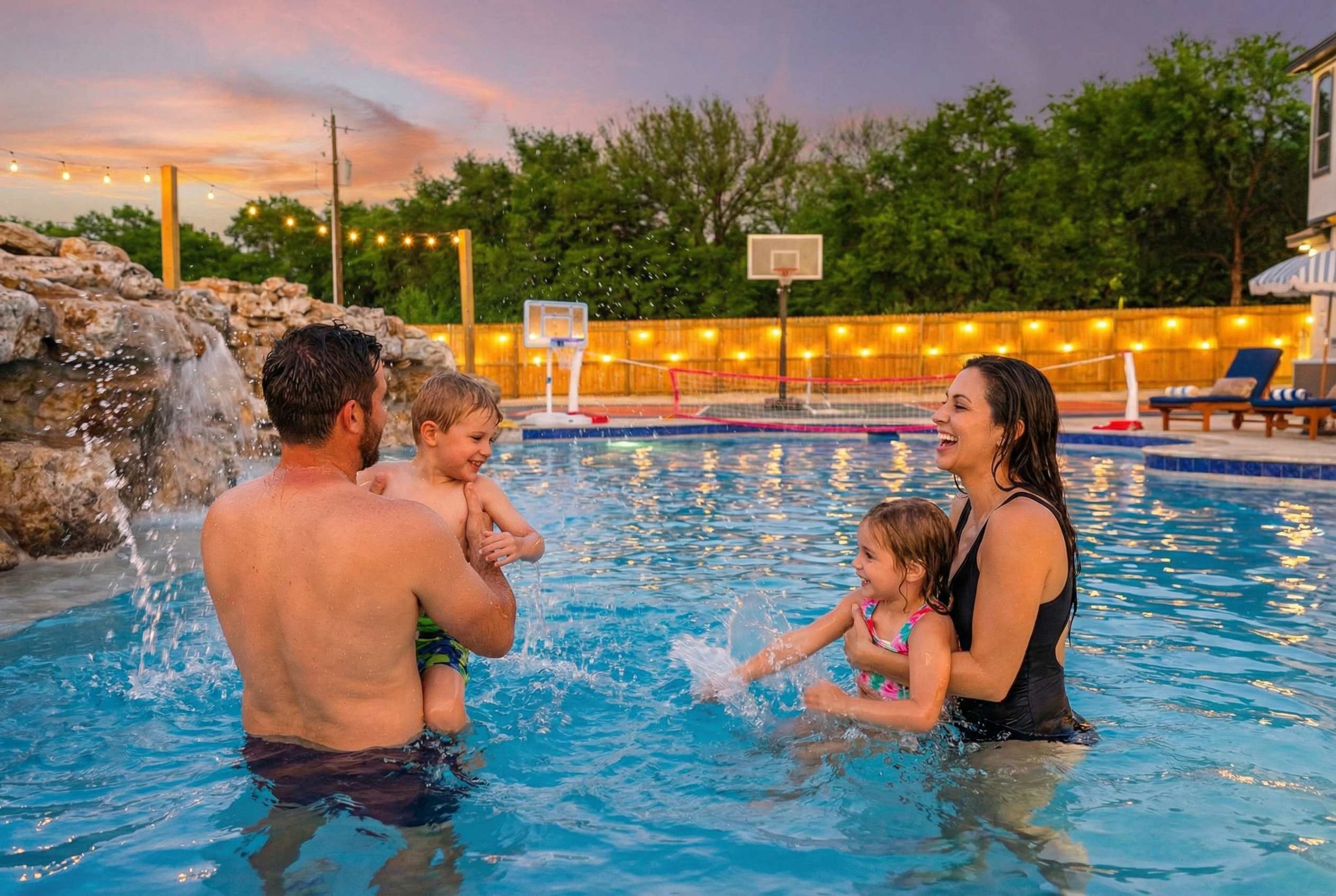 Una piscina con aro de baloncesto y una cascada.