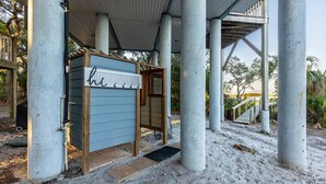A covered outdoor area with a wooden structure and a metal sign. - 3 Story Haven Fire Pit Kayaks Updated 360 Views (Cedar Key)
