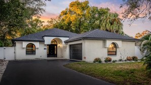 A two-story house with a garage, a driveway, and a well-maintained lawn. - 1 Mile to Honeymoon Island Pool Putt Putt (Palm Harbor)