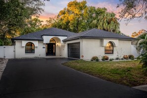 Ein zweistöckiges Haus mit Garage, Auffahrt und gepflegtem Rasen.