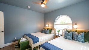 A hotel room with two beds, a ceiling fan, a window with a view, and a small green ottoman. - 1 Mile to Honeymoon Island Pool Putt Putt (Palm Harbor)