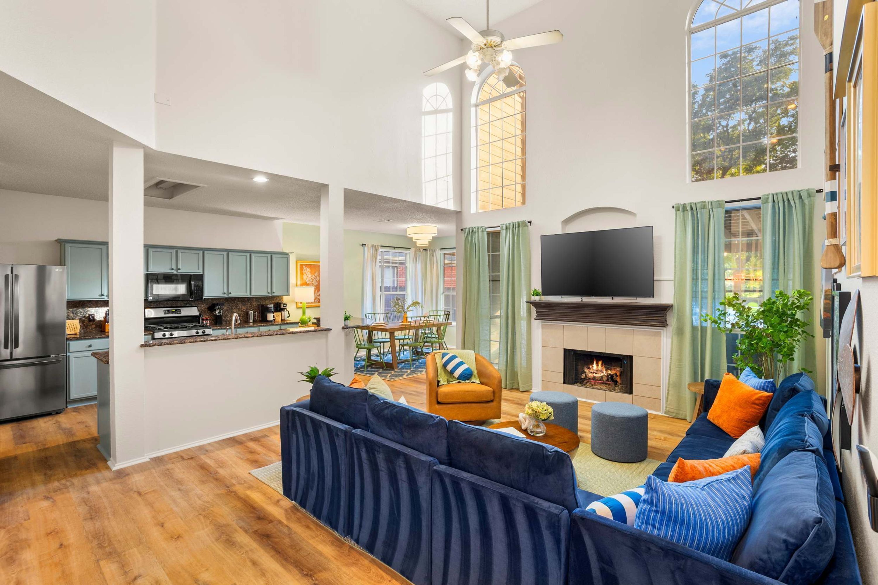A spacious living area with a large dark blue sofa, a fireplace, and a television.