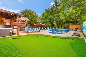 A backyard with a pool, a barbecue area, and a putting green. - The Painted Paddle Pool Hottub Pickleball Court (Lake Dallas)