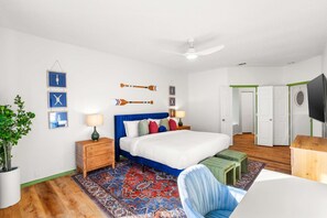 A bedroom with a bed, bedside tables, a nightstand, a chair, a television, and a door. - The Painted Paddle Pool Hottub Pickleball Court (Lake Dallas)