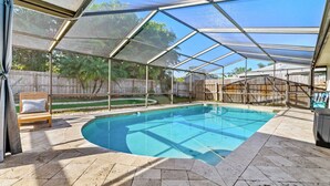 A covered outdoor swimming pool with a clear view of the surrounding area, including a wooden deck and a fenced backyard. - Pool Fire Pit Retreat Sleeps 14 - BBQ Grill (Largo)