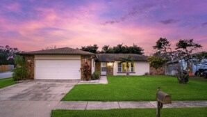 A single-story house with a garage, a well-maintained lawn, and a mailbox. - Pool Fire Pit Retreat Sleeps 14 - BBQ Grill (Largo)