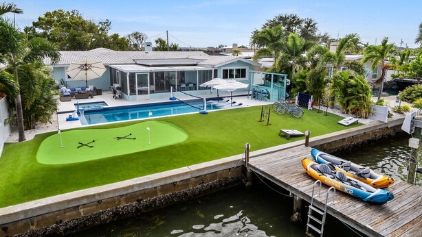 A residential property with a swimming pool, a tennis court, and a dock with kayaks. - Waterfront Walk to Beach Pool Kayaks Bikes (Indian Rocks Beach)