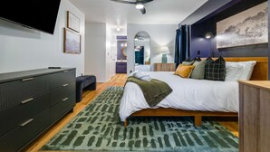 Un dormitorio moderno con cama, mesitas de noche, armario y ventilador de techo.