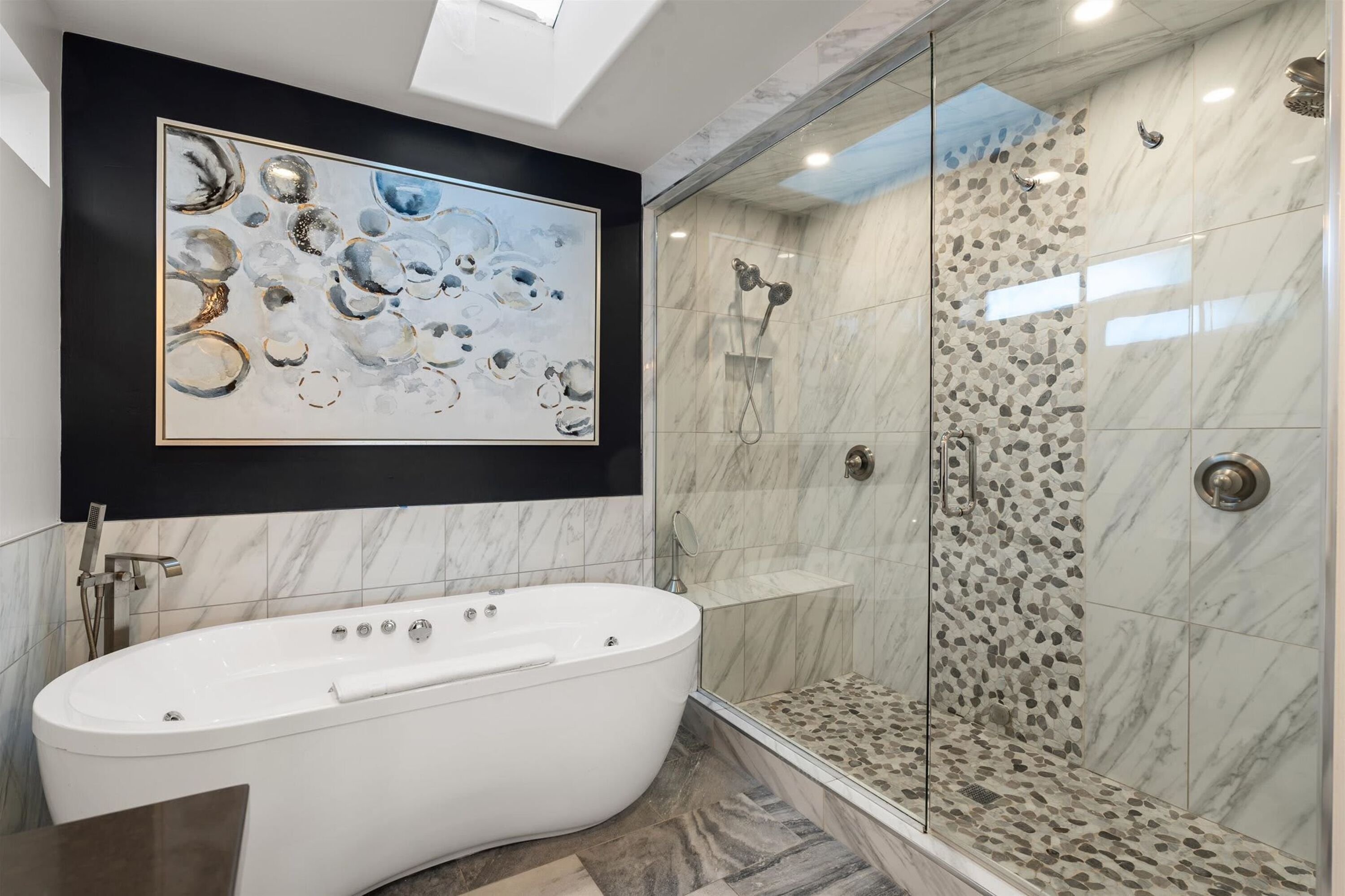 A modern bathroom with a freestanding bathtub, a glass-enclosed shower, and a marble floor.