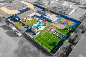 Luftaufnahme einer Freizeiteinrichtung mit Schwimmbad, Tennisplätzen und Fußballfeld.