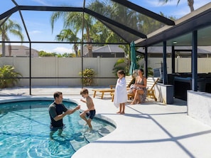 A swimming pool with a covered area, lounge chairs, and a patio. - Poolside Oasis Sleeps 8 Game Room Putt Putt (Bradenton)