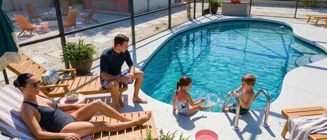A swimming pool with lounge chairs and a mural in the background.