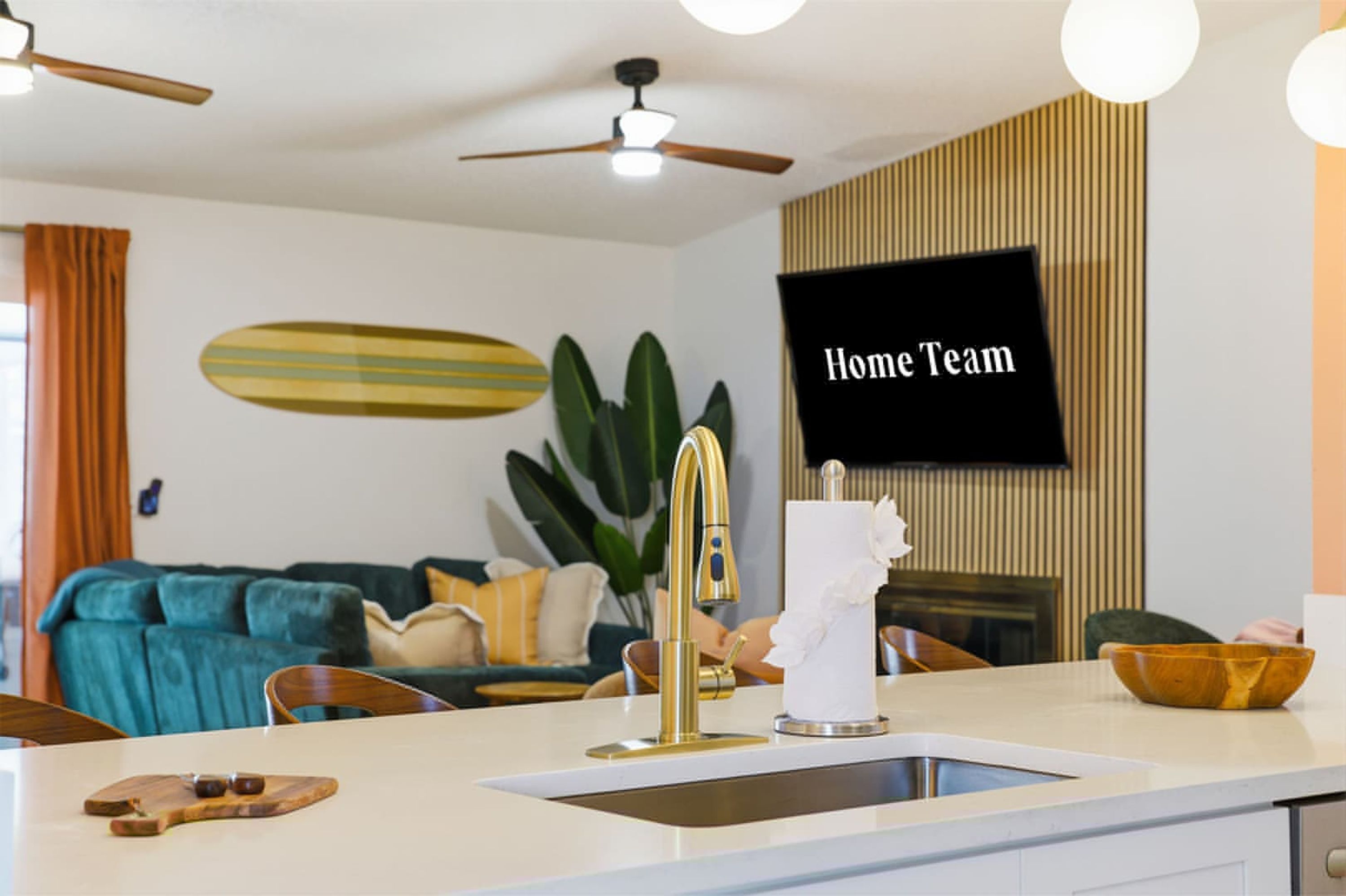 Una cucina moderna con lavello integrato, un piano di lavoro e una ventola a soffitto.