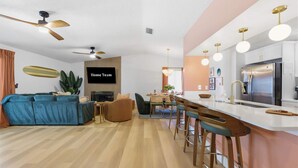 Ein modernes Wohnzimmer mit einer Couch, einem Fernseher und einem Deckenventilator.