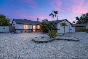 A two-story house with a gravel driveway and a small garden area. - Poolside Oasis Sleeps 8 Game Room Putt Putt (Bradenton)