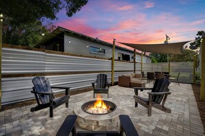 A patio area with a fire pit, outdoor seating, and a view of a house. - Sunny Citrus Escape Min to Midtown Dog-friendly (Tampa)