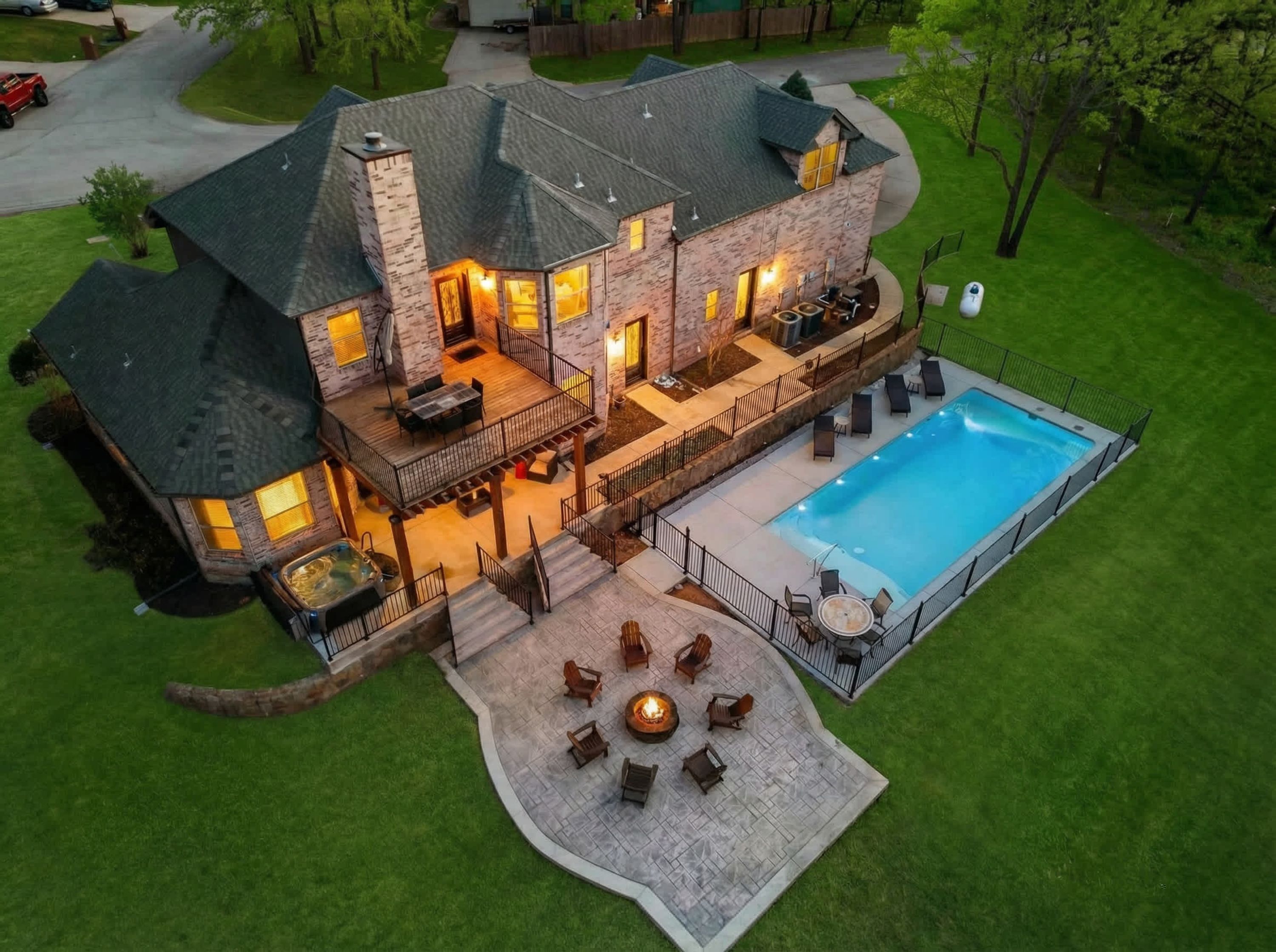 A large house with a swimming pool, outdoor seating, and a fire pit.