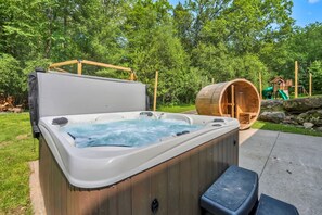 A hot tub with a wooden exterior, a wooden deck, and a play structure in the background. - Sleeps 14 Pool Hot Tub Sauna Pickleball Arcade (Stroudsburg)