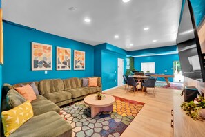 Un salon moderne avec un canapé, une table basse et des œuvres d’art accrochées au mur.