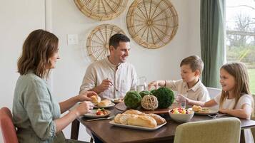 A family dining at a table with a view of the outdoors.