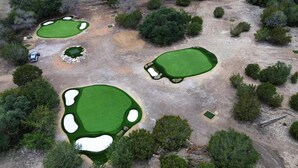 An aerial view of a golf course with multiple greens, sand bunkers, and a few trees. - Birdie Creek Ranch - Private Golf Course Resort (Driftwood)