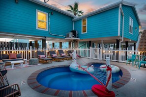 A pool area with lounge chairs and a small inflatable pool. - The Wave House Sleeps 16 Pool Hot Tub Bikes (Port Aransas)