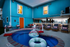 Um imóvel residencial com piscina, área de estar externa e um deck cercado.