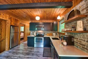 Una cocina compacta con armarios de madera, horno empotrado, microondas y cafetera.