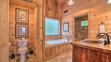 A wooden cabin bathroom with a toilet, sink, and bathtub.