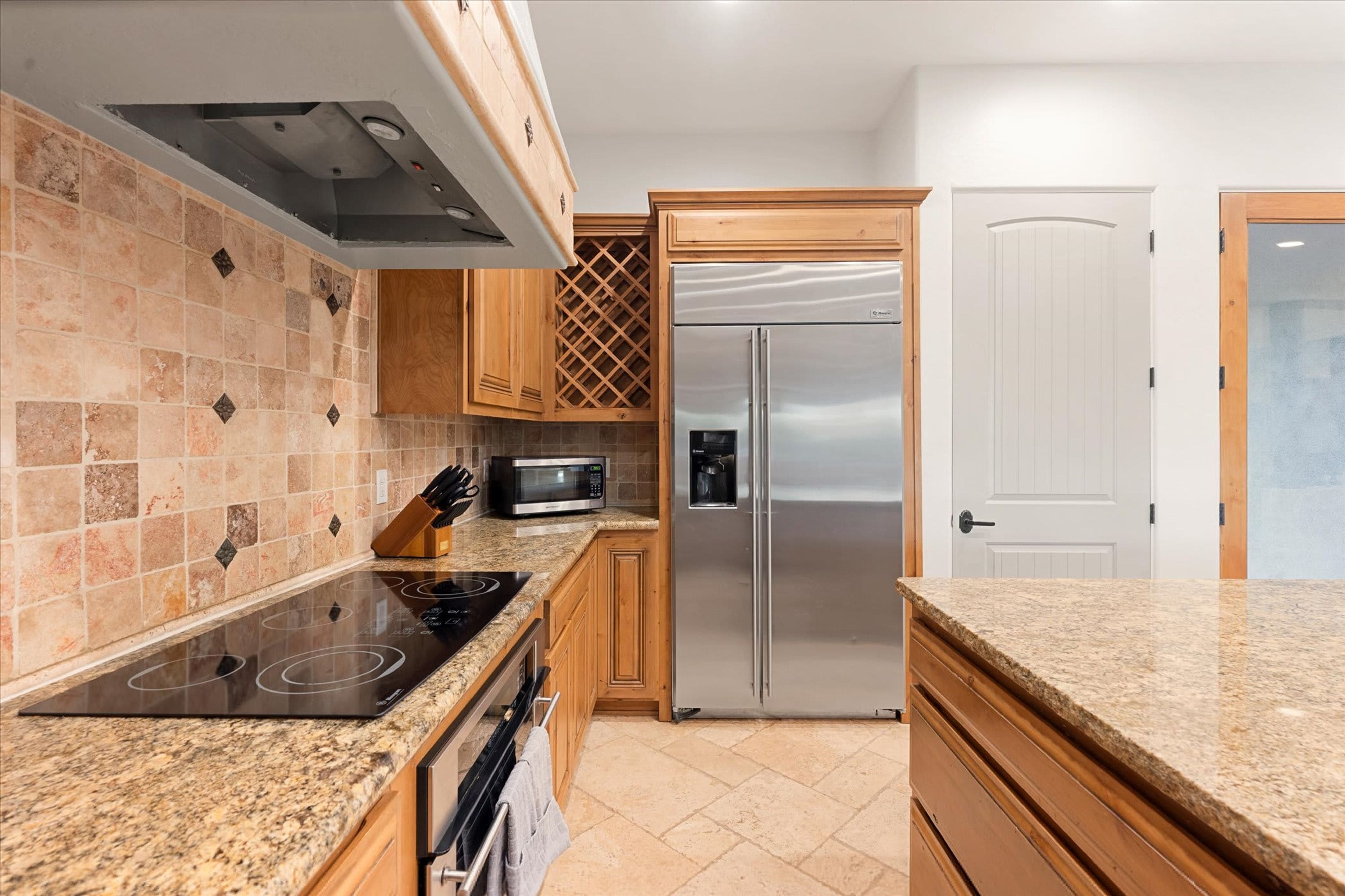 A modern kitchen with a built-in microwave, stainless steel refrigerator, and a gas stove.