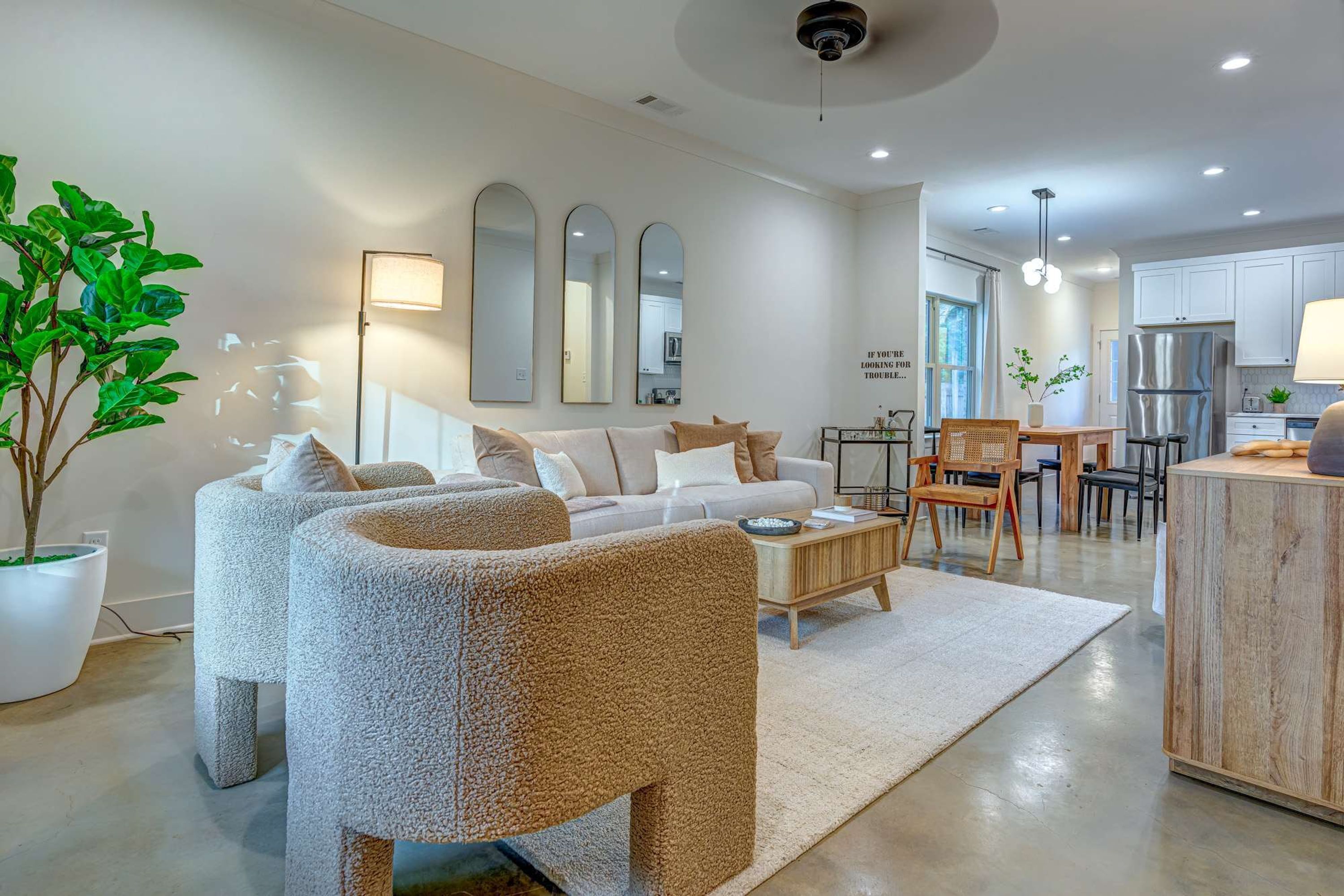 Un salon moderne comprenant un canapé, une table basse et un coin repas avec des chaises et une table.