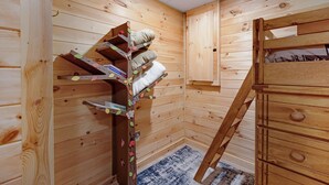 A wooden interior with a bunk bed, a small bookshelf, and a cabinet. - Mountain Views w Slide Hot Tub Game Room (Mineral Bluff)