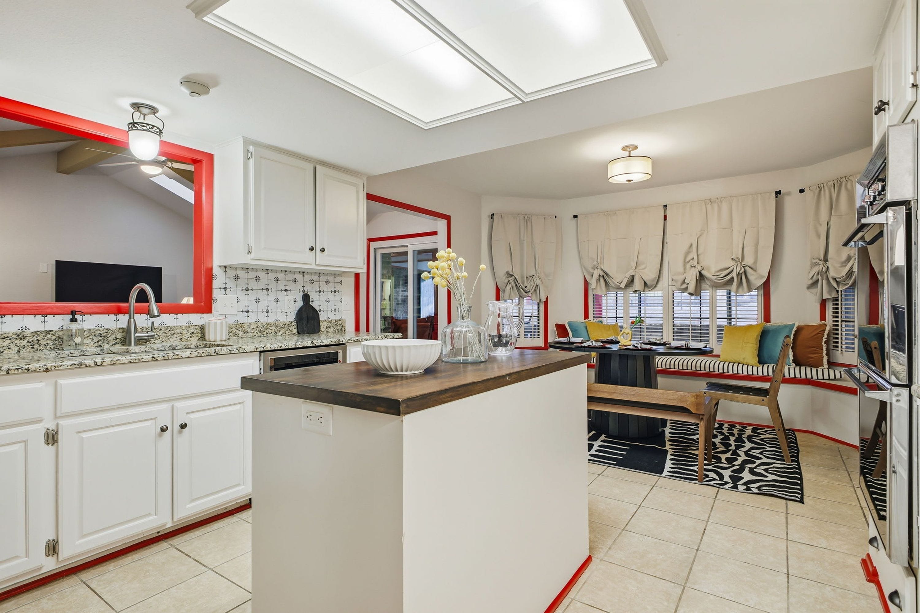 A modern kitchen with white cabinets, a granite countertop, and a central island.