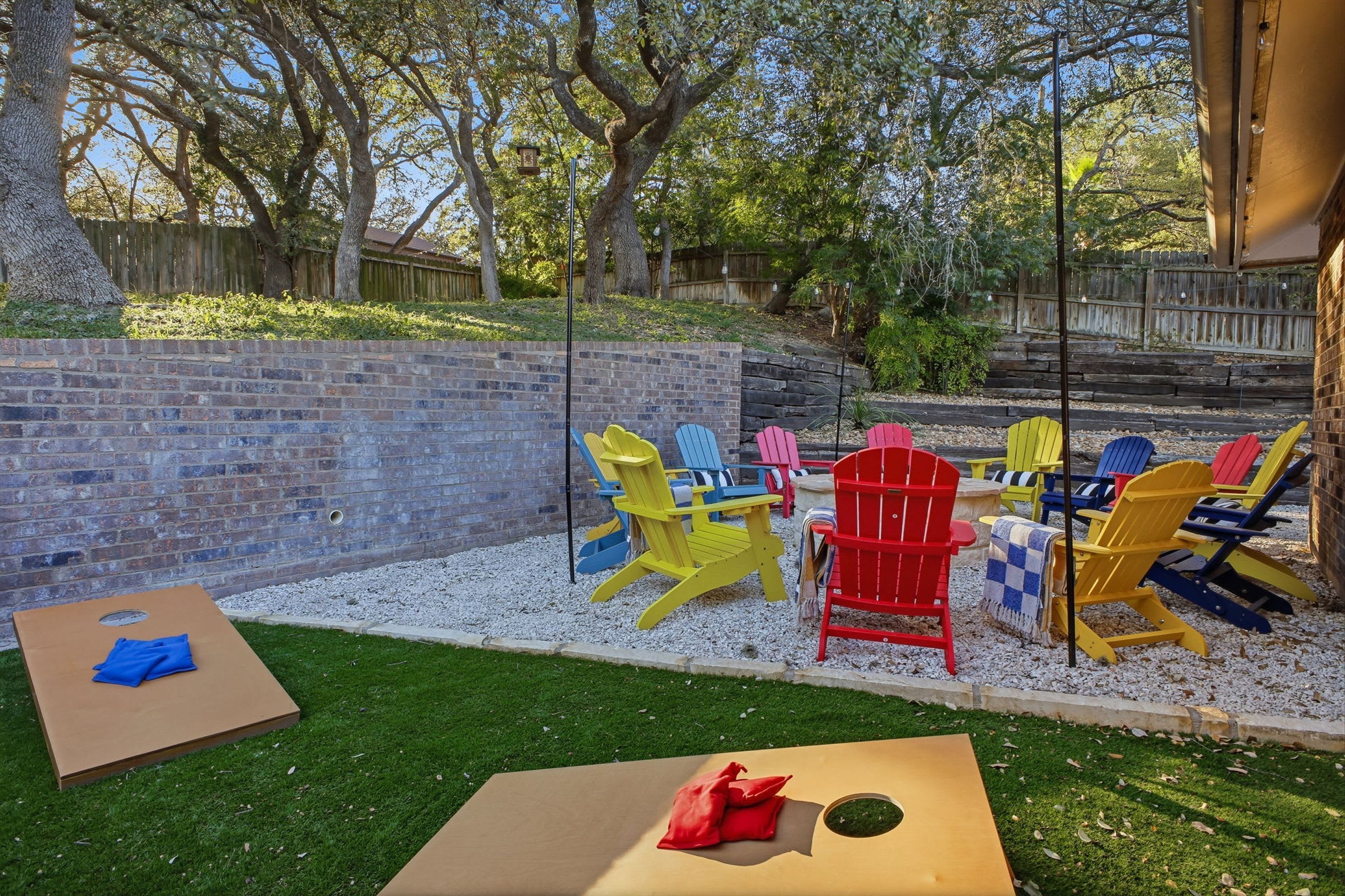 A backyard with a brick wall, a wooden fence, and a grassy area.