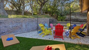 A backyard with a brick wall, a wooden fence, and a grassy area.
