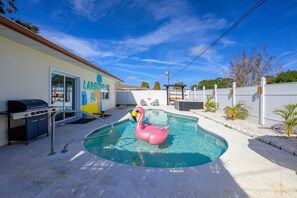 A backyard with a swimming pool, a barbecue grill, and a flamingo float. - Backyard Oasis Pool Hot Tub Putt Putt Bar (Largo)